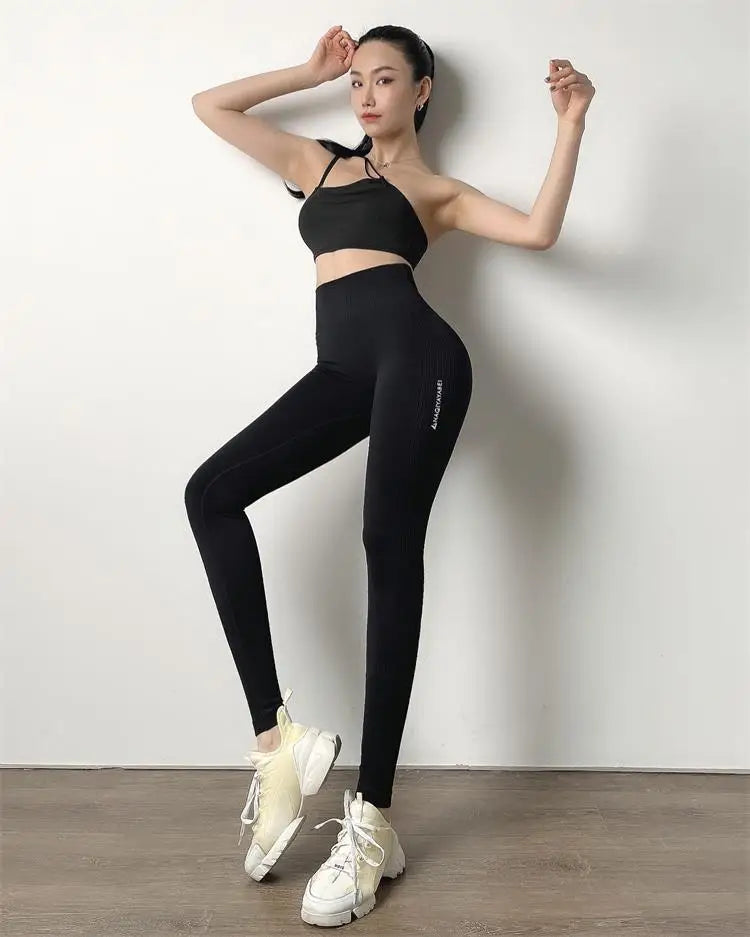 KiKis High Waist Push Up Seamless Leggings in black worn by model with black crop top and white sneakers
