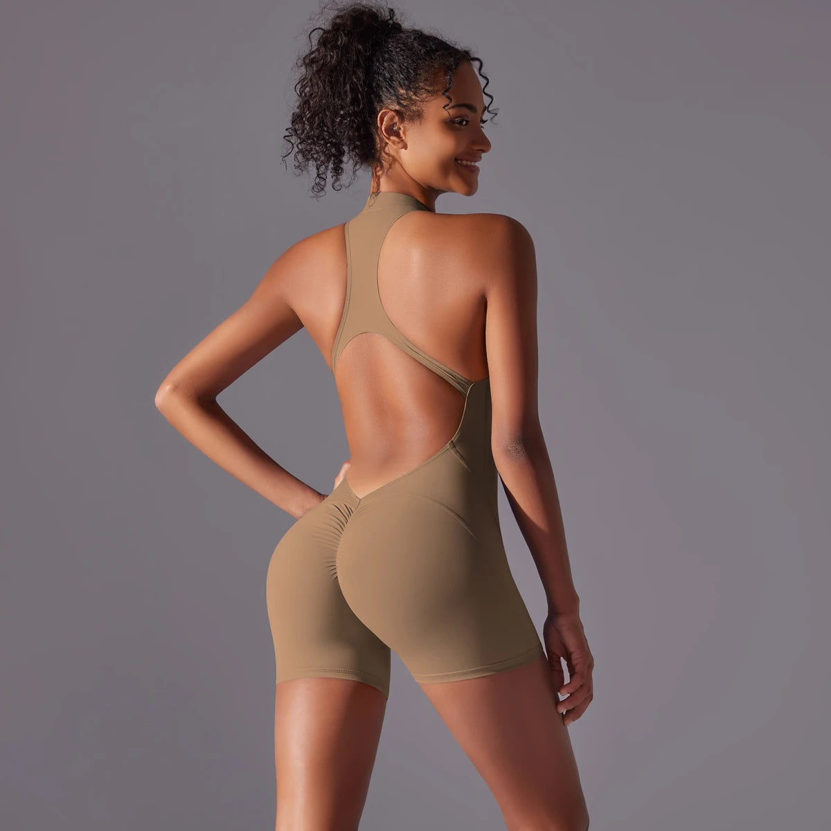 KiKis backless gym bodysuit for women in beige with racerback and fitted shorts design