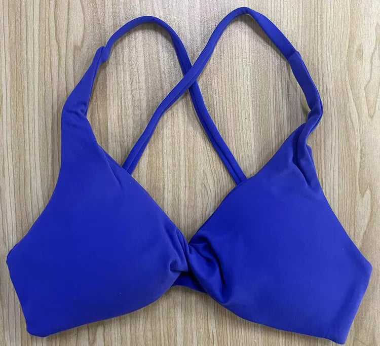 KiKis royal blue padded front twist sports bra with crisscross straps on wooden background