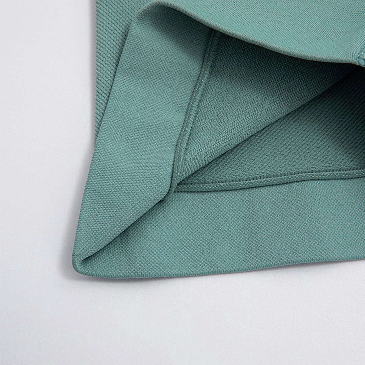 Close-up of green fabric texture and stitching on high waist gym shorts for women by KiKis