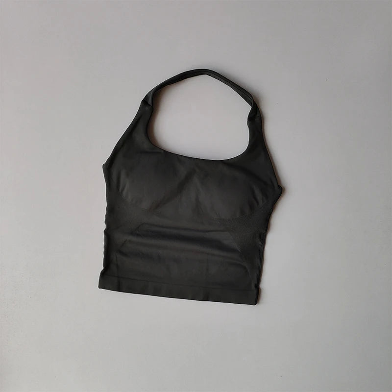 Black halter neck sports bra for women laid flat on gray surface from KiKis