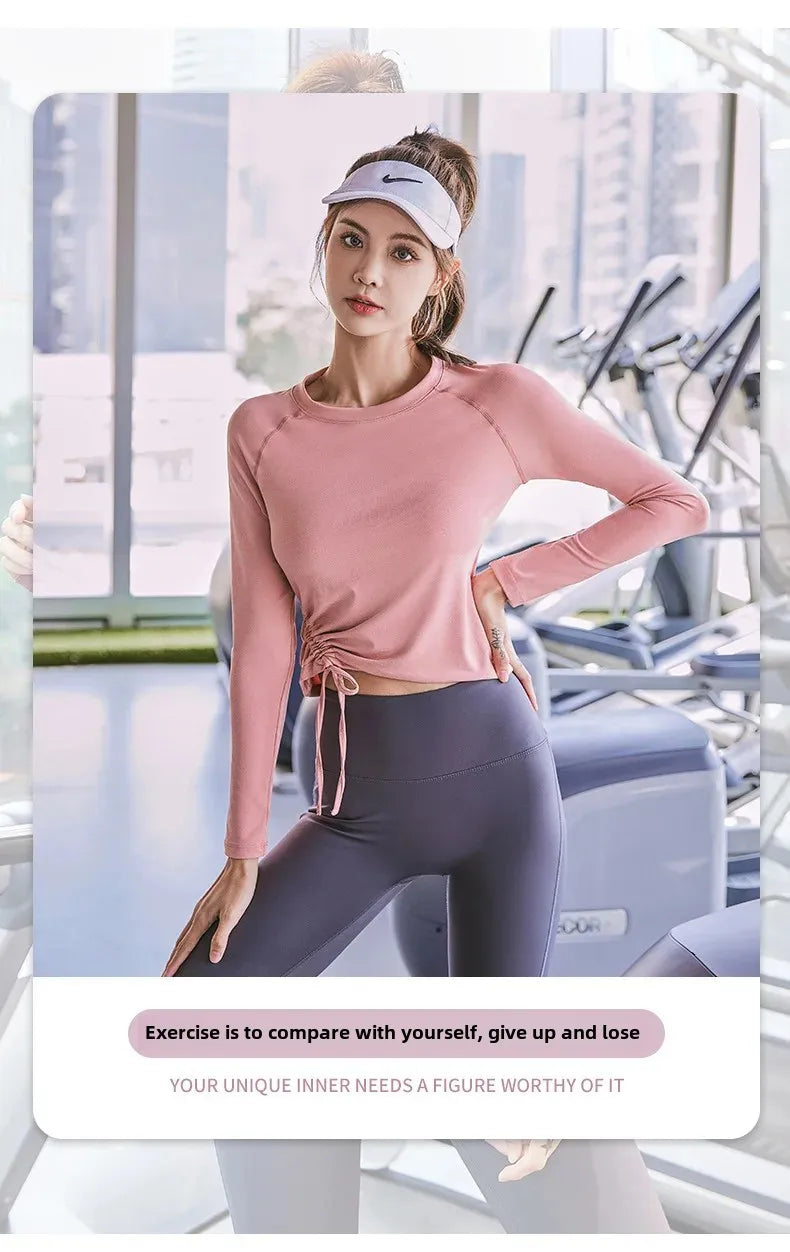 Women's long sleeve yoga top in pink by KiKis modeled in a gym setting