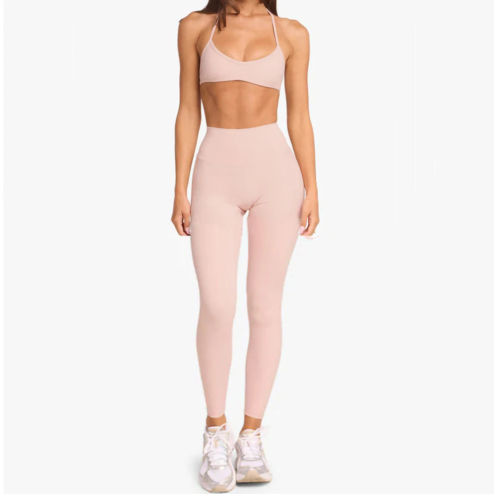 KiKis women's cross wrap yoga shirt in light pink modeled with matching high-waist leggings