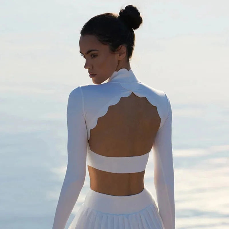 KiKis long sleeve lace back yoga top in white worn by woman with open scalloped back design