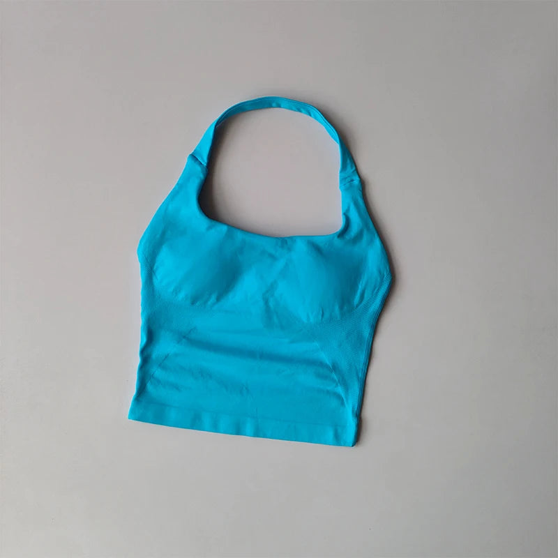 Blue halter neck sports bra for women laid flat on a gray background