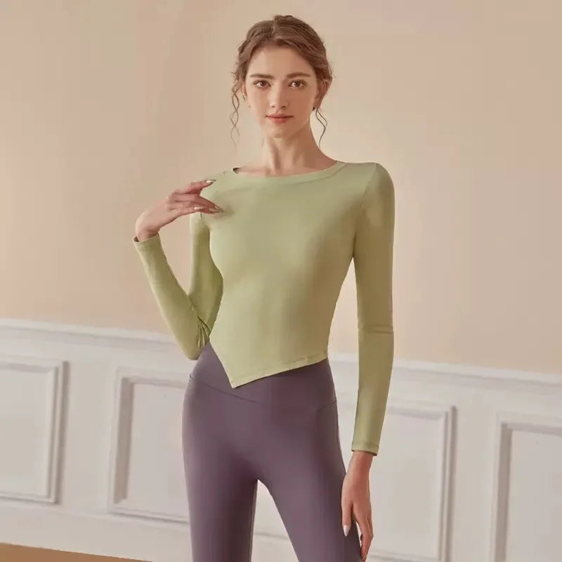 KiKis women's long sleeve yoga top in light green with asymmetrical hem worn by model