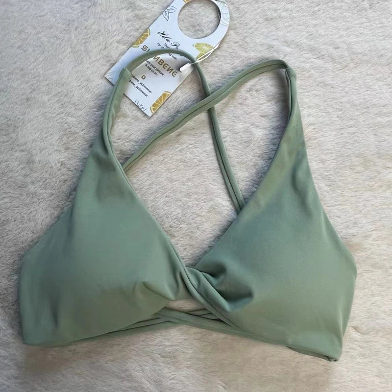 KiKis padded front twist sports bra in sage green with crisscross straps and soft fabric