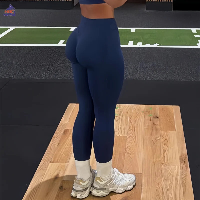 KiKis Women Scrunch Butt Seamless Leggings in navy blue paired with white sneakers