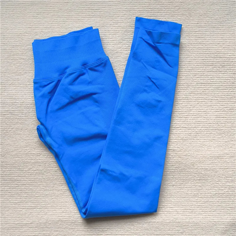 KiKis Women Scrunch Butt Seamless Leggings in vibrant blue folded flat on beige surface