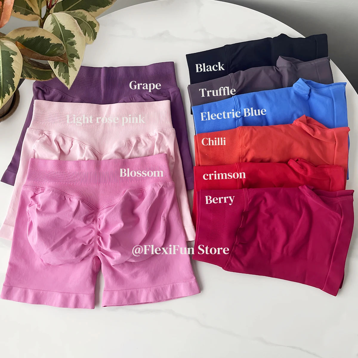 Collection of KiKis high waist gym shorts for women in various colors including grape, light rose pink, blossom, black, truffle, electric blue, chili, crimson, and berry