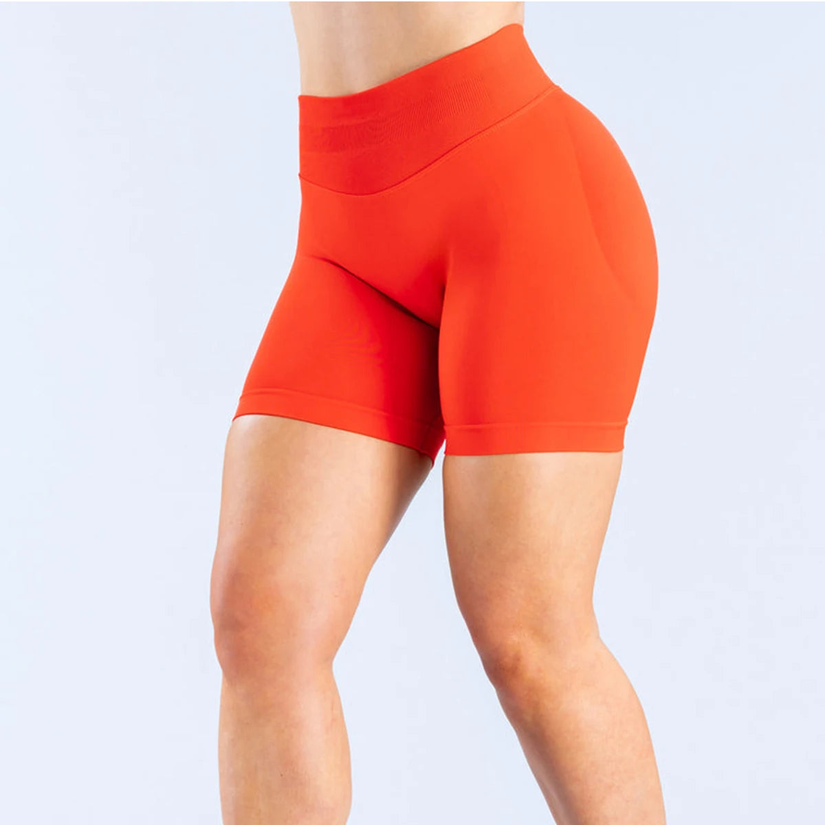 Bright orange high waist gym shorts for women with a smooth, fitted design for active wear