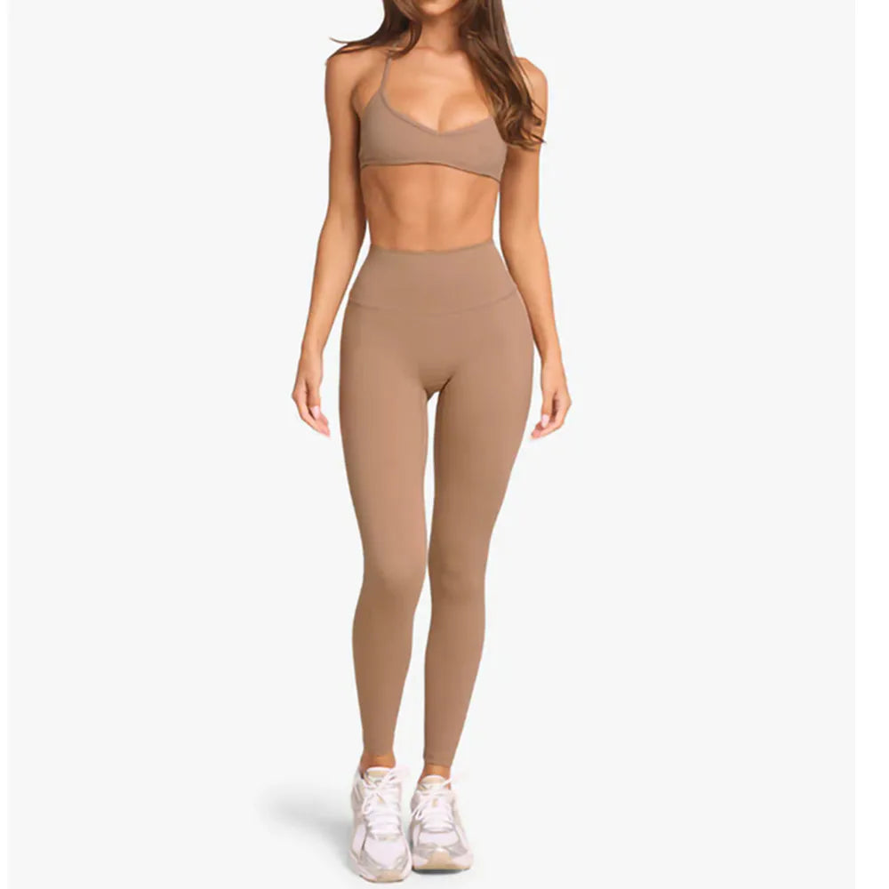 KiKis women's cross wrap yoga shirt in beige worn with matching high-waist leggings and white sneakers