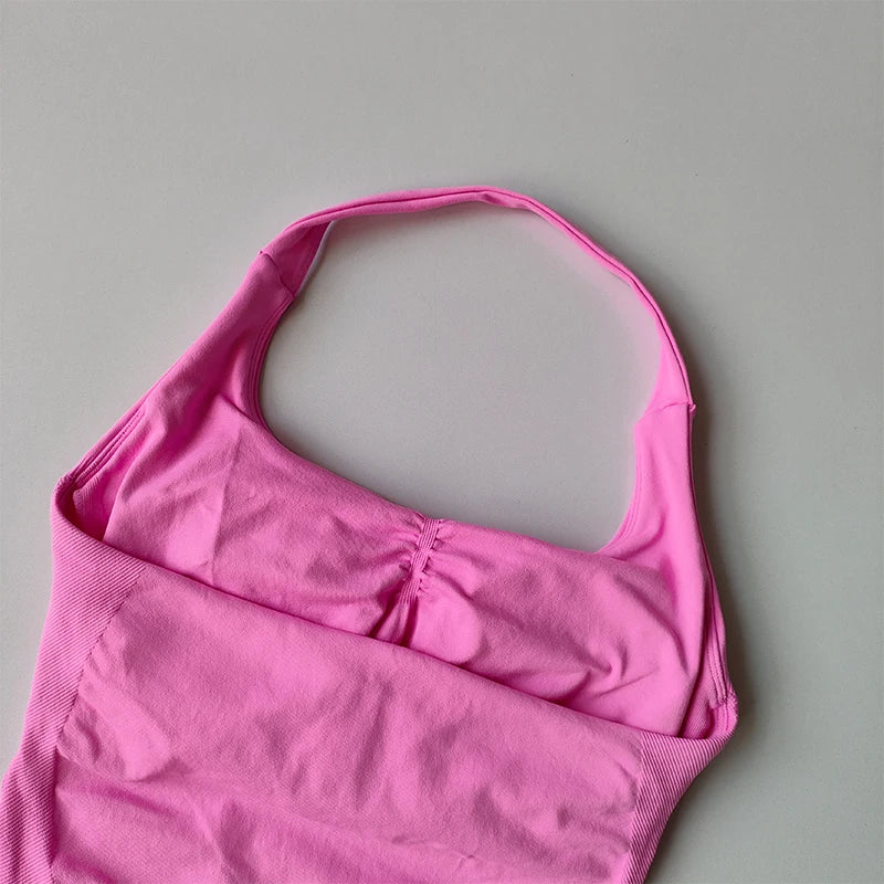 Pink halter neck sports bra for women by KiKis laid flat on a light surface