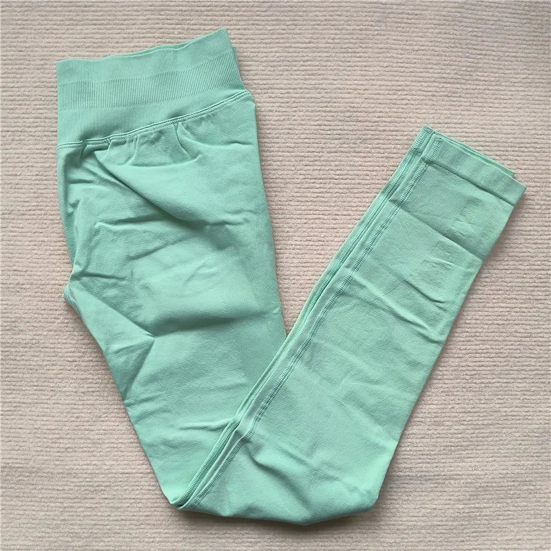 KiKis Women Scrunch Butt Seamless Leggings in light green folded on beige surface