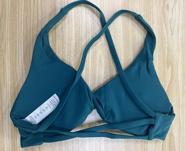 KiKis padded front twist sports bra in teal with crisscross straps and soft fabric