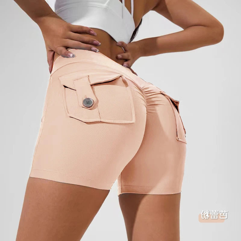 KiKis women's scrunch booty shorts in light peach with back button pockets and a high waist design