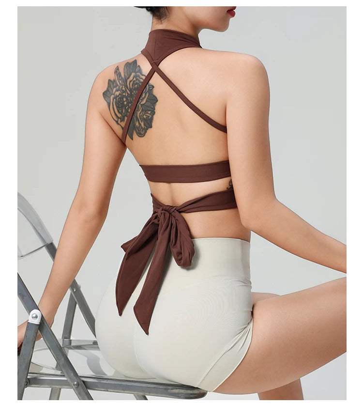 Woman wearing brown comfortable workout tank tops for women with back tie detail sitting on metal chair