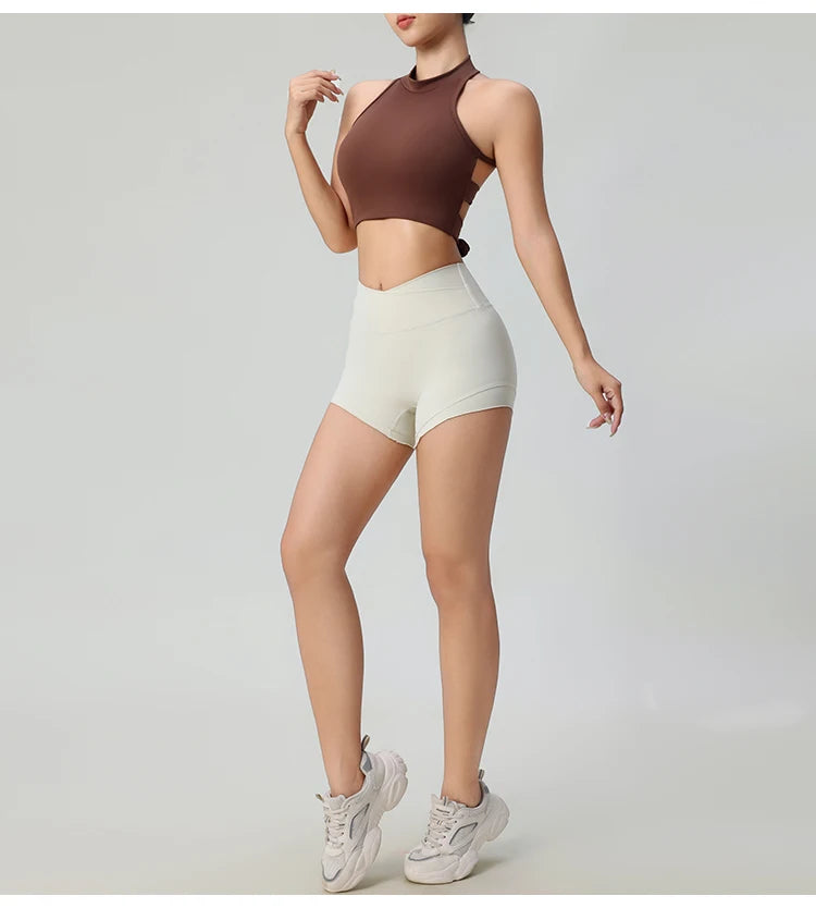 Woman wearing a brown comfortable workout tank tops for women paired with white high-waisted shorts and white sneakers