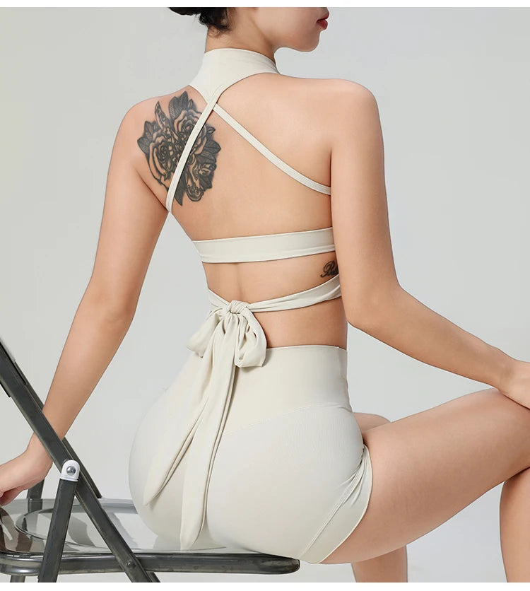 Back view of woman wearing comfortable workout tank tops for women in beige with stylish straps and tie detail