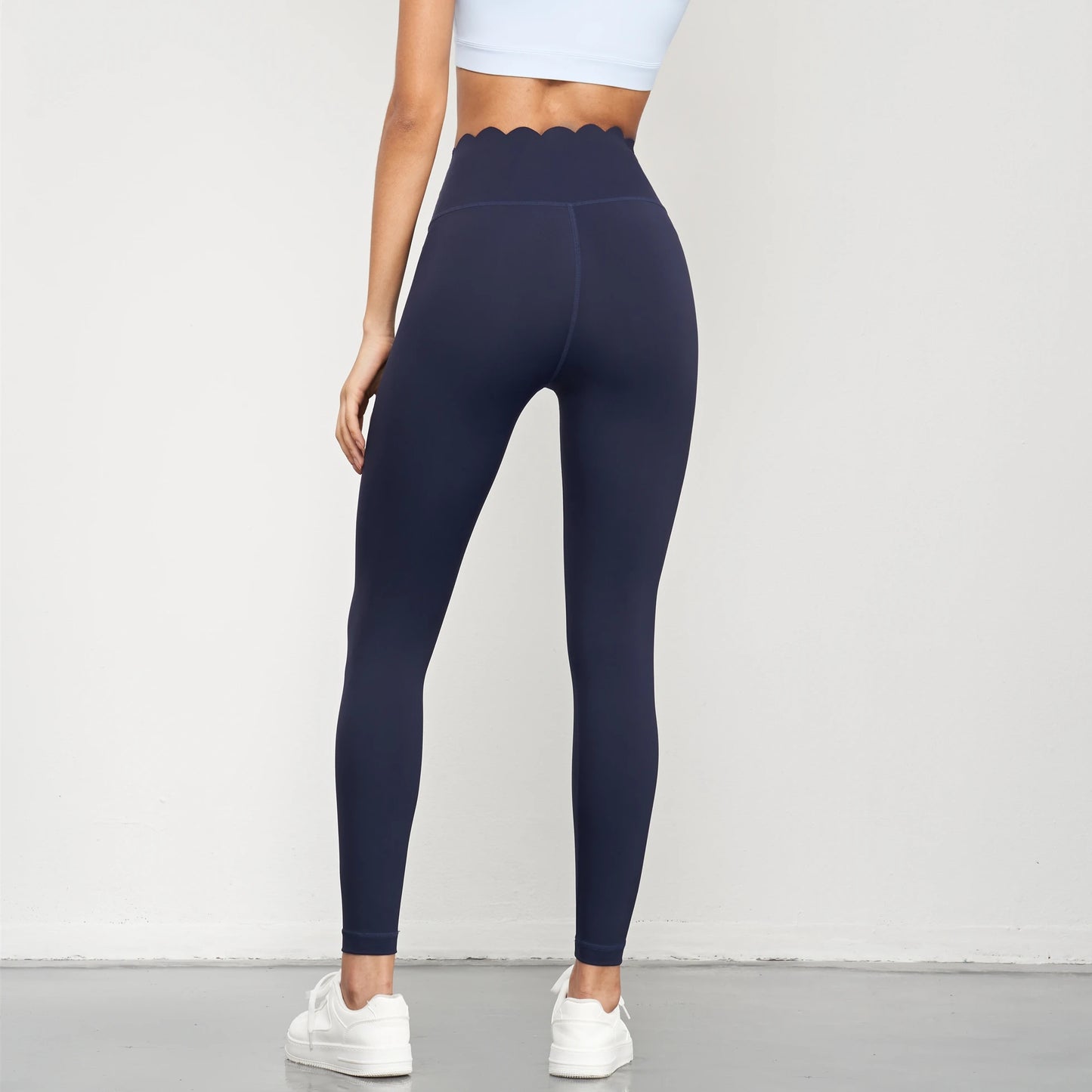 Back view of Women Seamless Lotus Arc Yoga Pants in navy blue with scalloped waistband