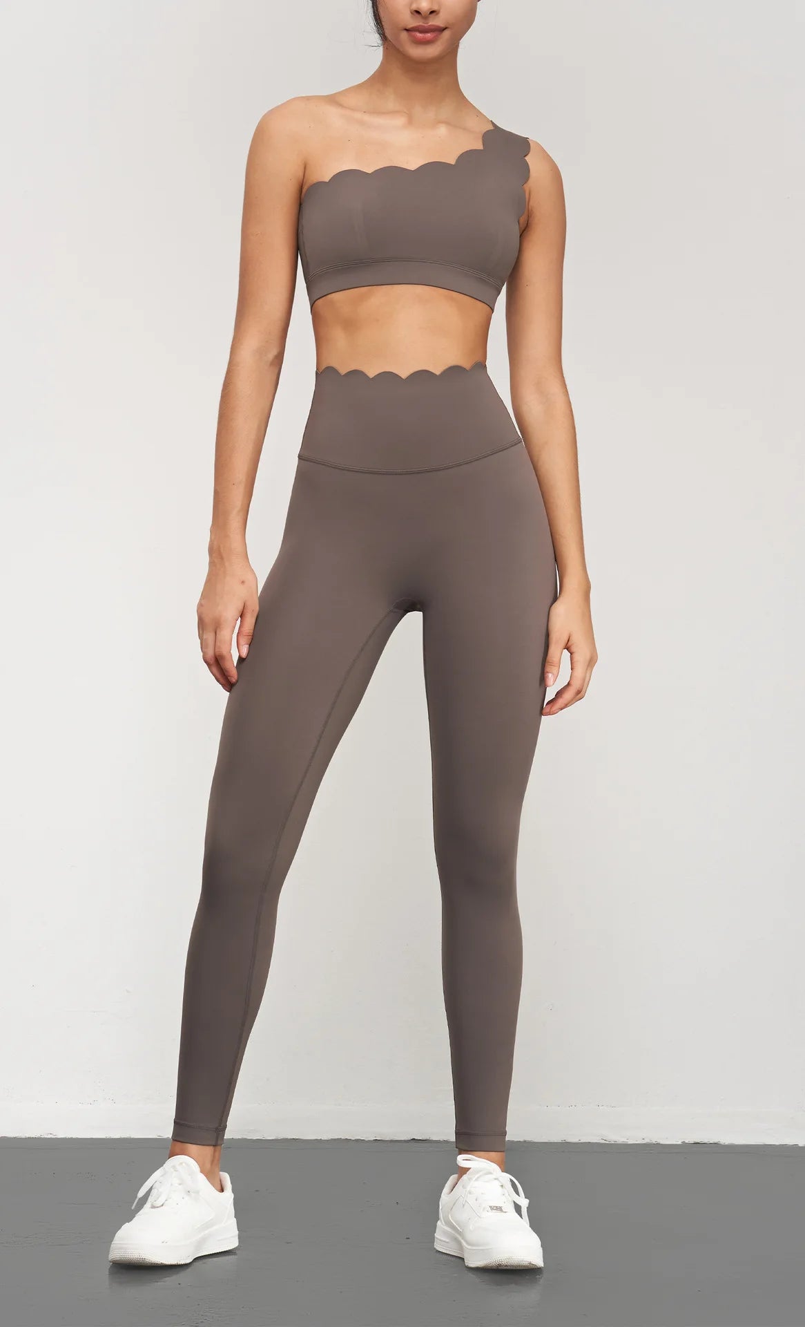Women wearing brown Women Seamless Lotus Arc Yoga Pants with matching one-shoulder top and white sneakers