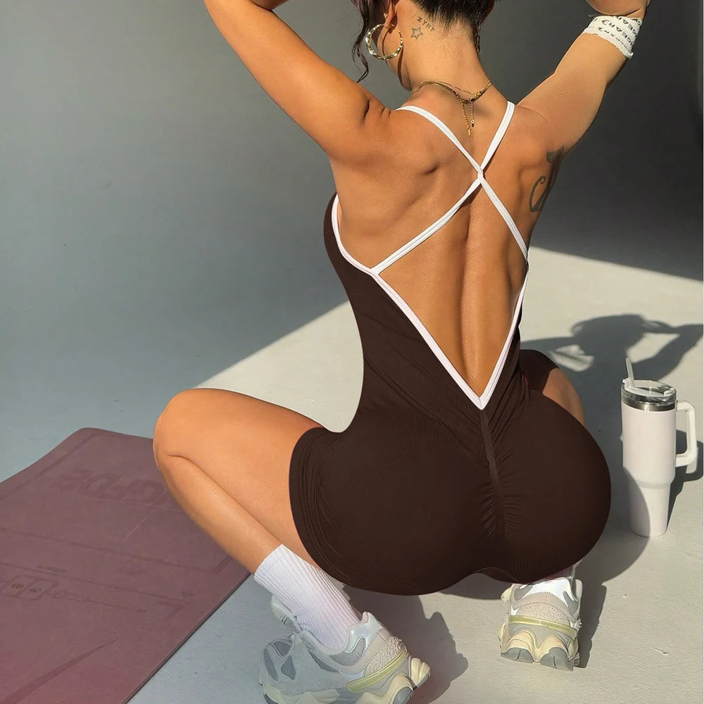 KiKis black cross back strappy jumpsuit with white trim worn by woman in athletic pose