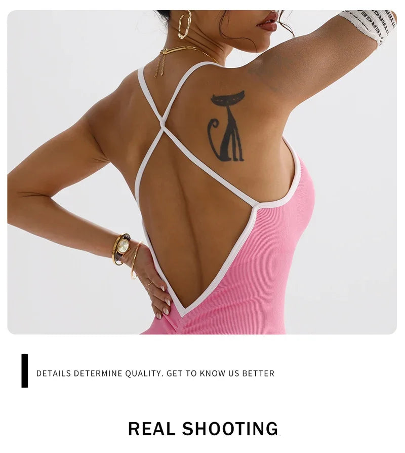 Woman wearing pink KiKis cross back strappy jumpsuit showing tattoo and gold accessories