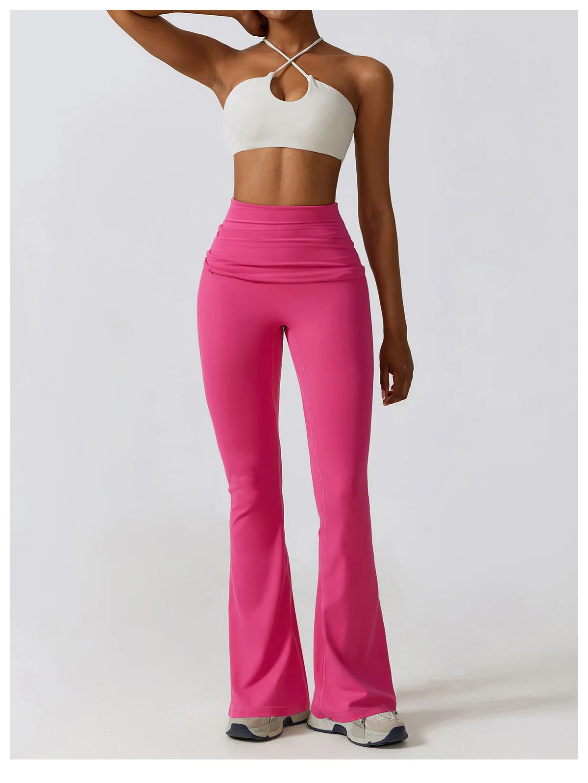 Woman wearing a pink one piece yoga suit for women with a white crop top and sneakers