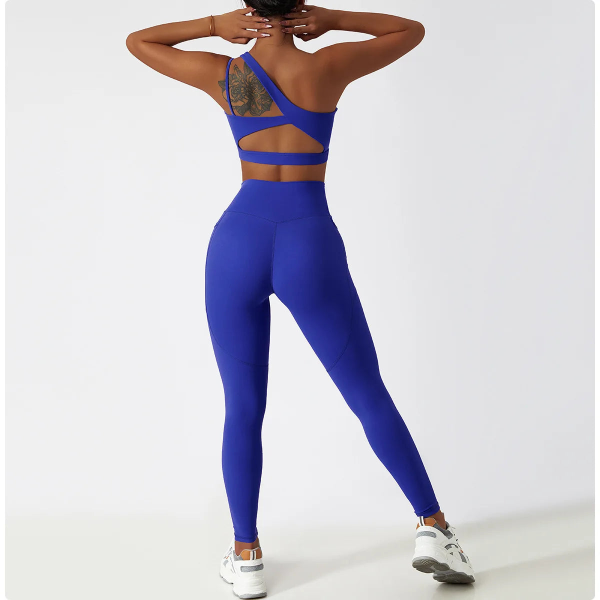 KiKis one shoulder sports bra and leggings set in royal blue worn by a model from the back