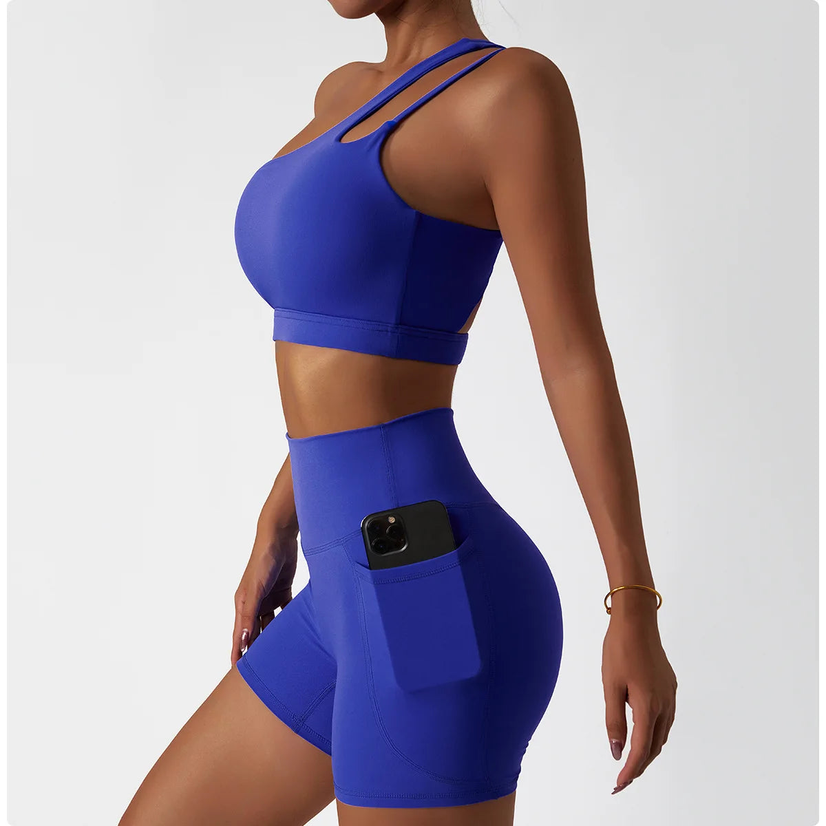 KiKis one shoulder sports bra and leggings set in blue with phone pocket on leggings