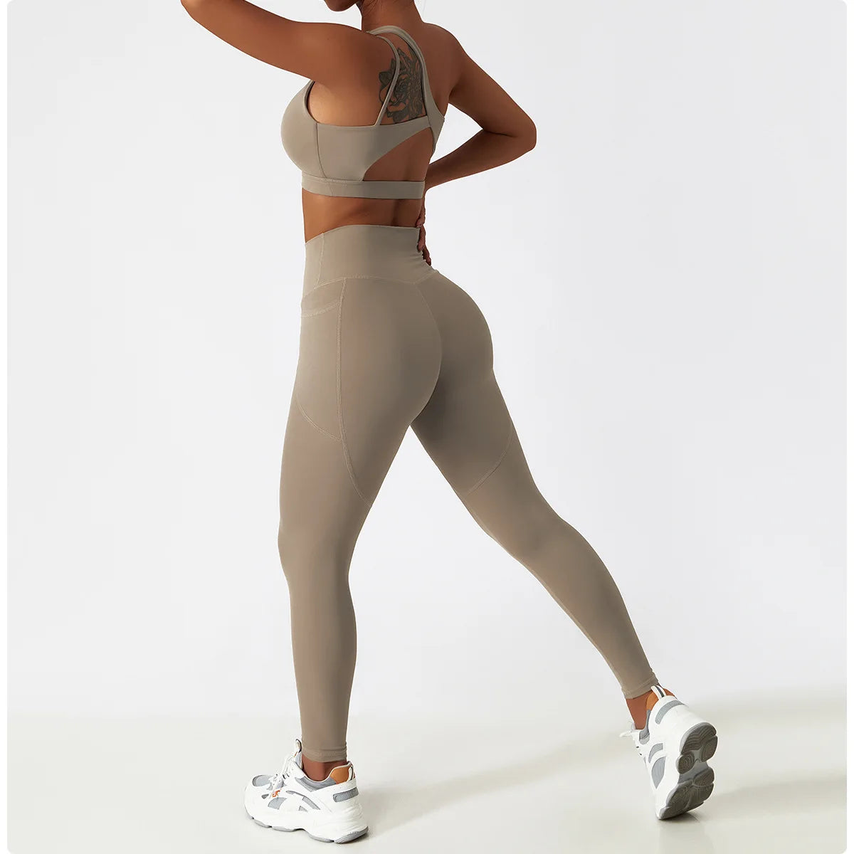 Woman wearing KiKis one shoulder sports bra and leggings set in beige with white sneakers