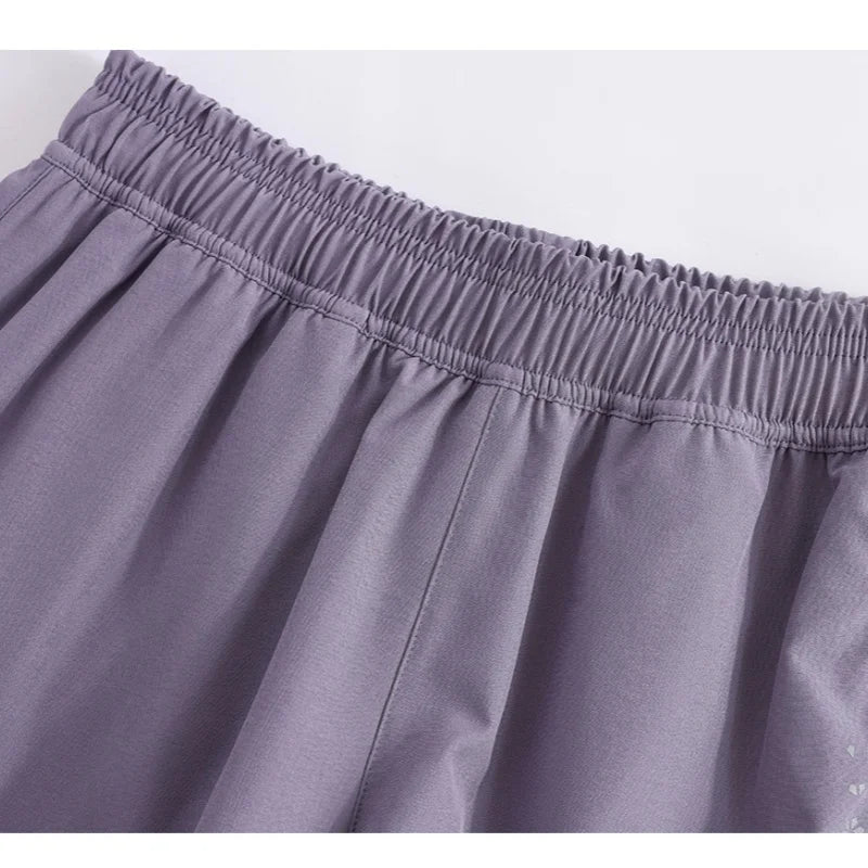 Close-up of purple KiKis high waist running shorts for women showing elastic waistband and fabric texture