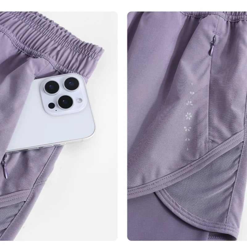 KiKis high waist running shorts for women in purple featuring a zippered pocket holding a smartphone