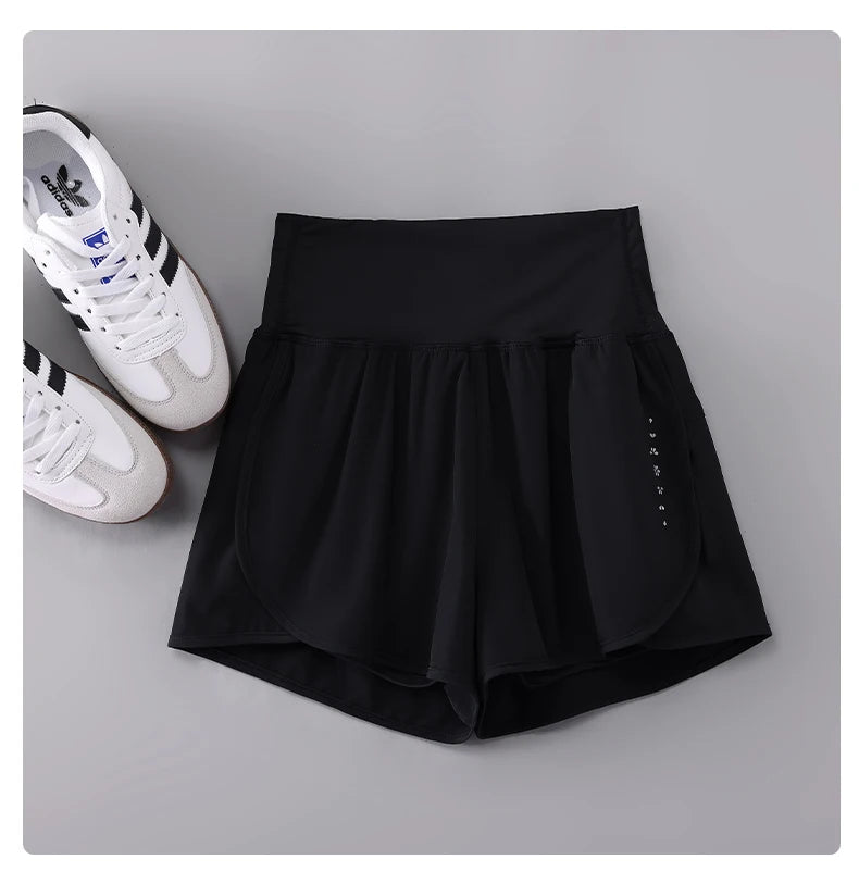 KiKis black Womens Running Shorts with high waist and breathable fabric beside white Adidas sneakers