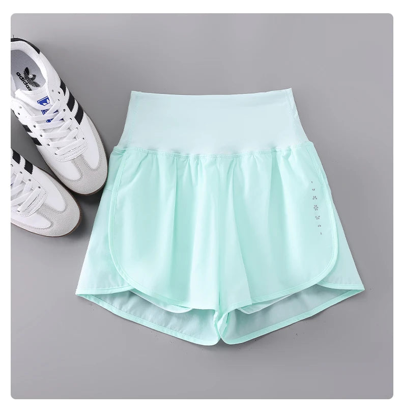 KiKis light blue Womens Running Shorts with high waist and soft fabric next to white sneakers