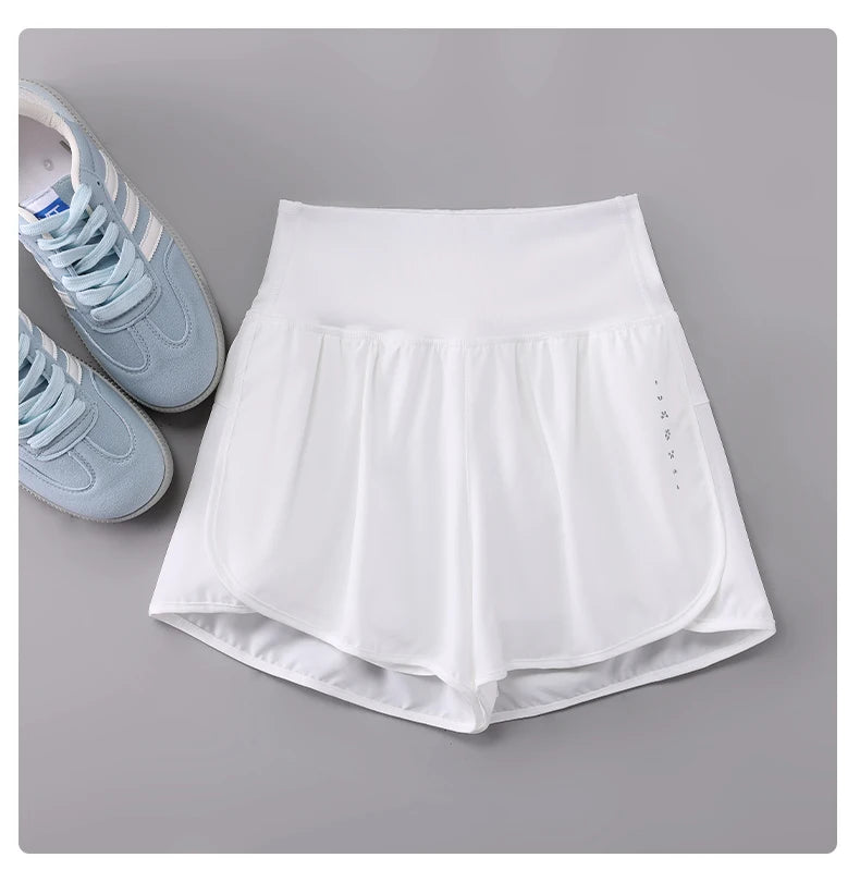 KiKis white Womens Running Shorts with high waistband and side pockets next to light blue running shoes