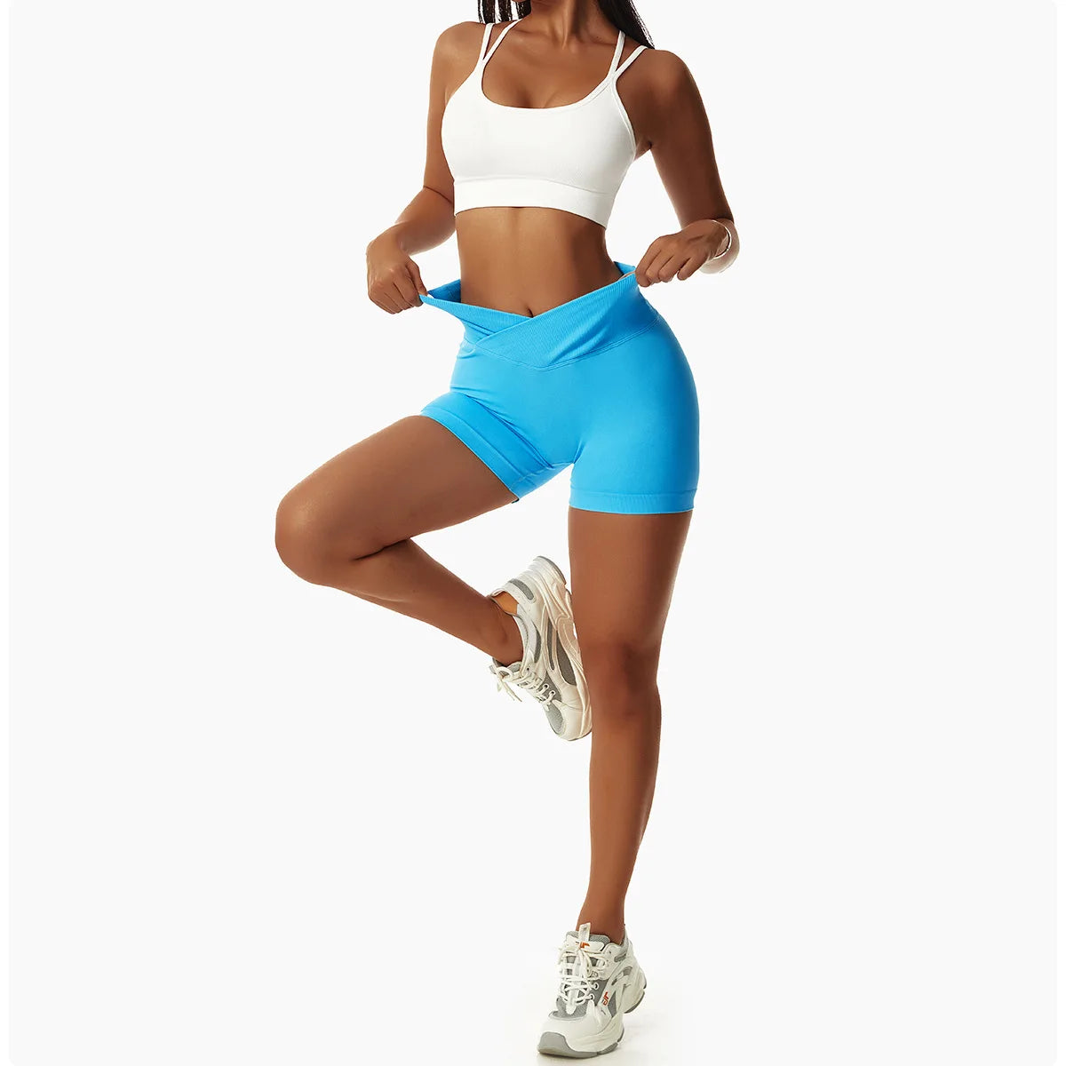 KiKis high waist seamless yoga shorts in blue worn by woman with white sports bra and sneakers