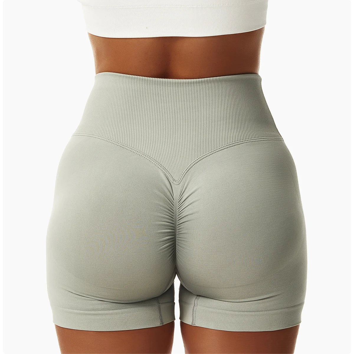 KiKis high waist seamless yoga shorts in light gray shown from the back with ruched detailing