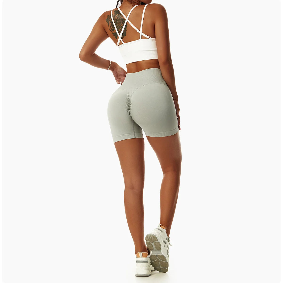 Woman wearing KiKis high waist seamless yoga shorts in light green with white sports bra and sneakers