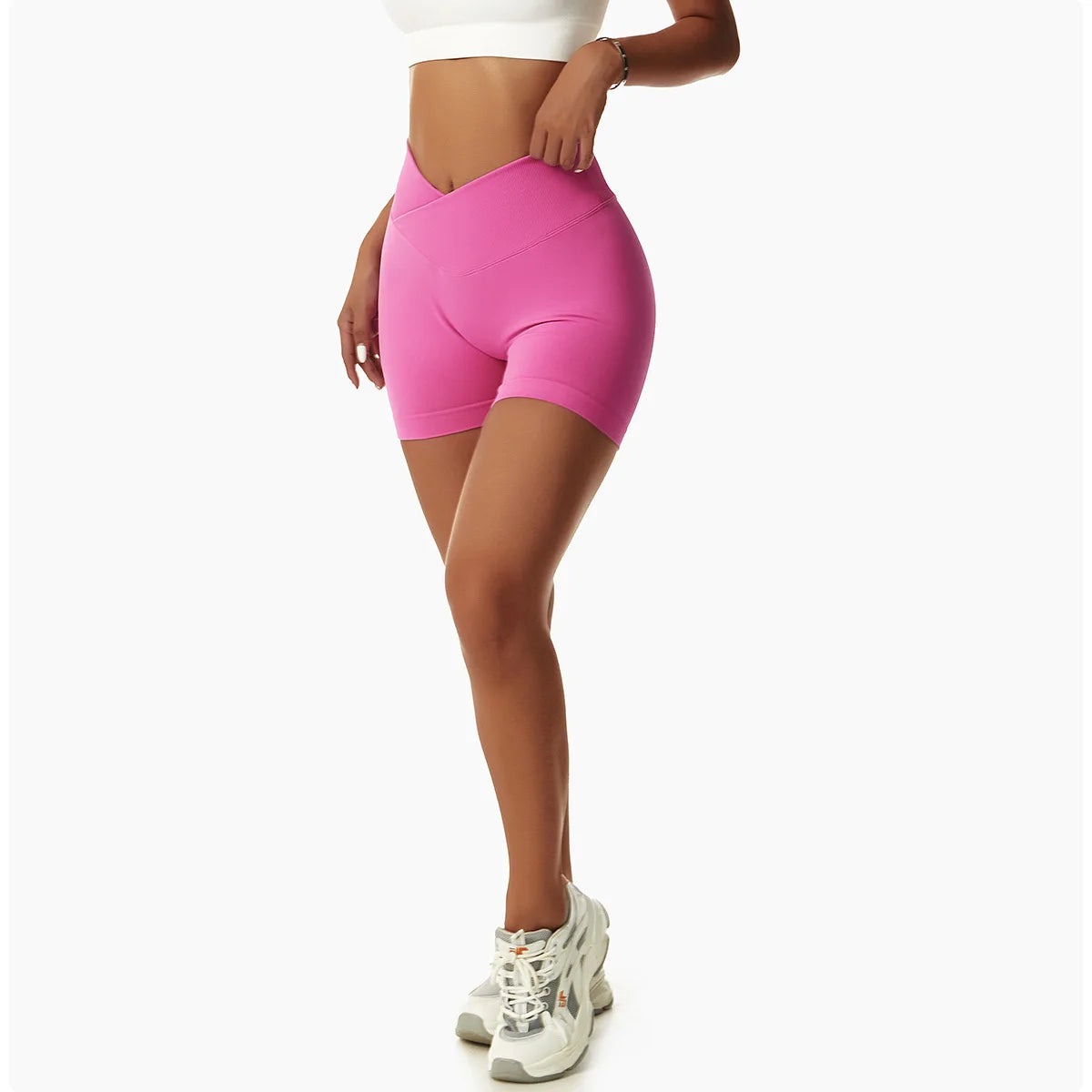 KiKis pink high waist seamless yoga shorts worn by woman with white sneakers and white crop top