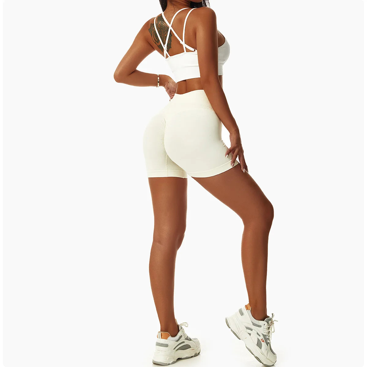 Woman wearing KiKis high waist seamless yoga shorts in light color with a matching sports bra and sneakers