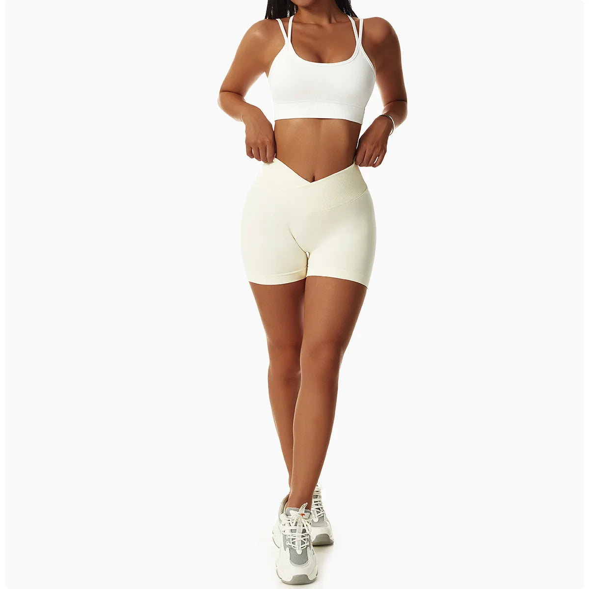 KiKis high waist seamless yoga shorts in light beige worn by woman with white sports bra and sneakers