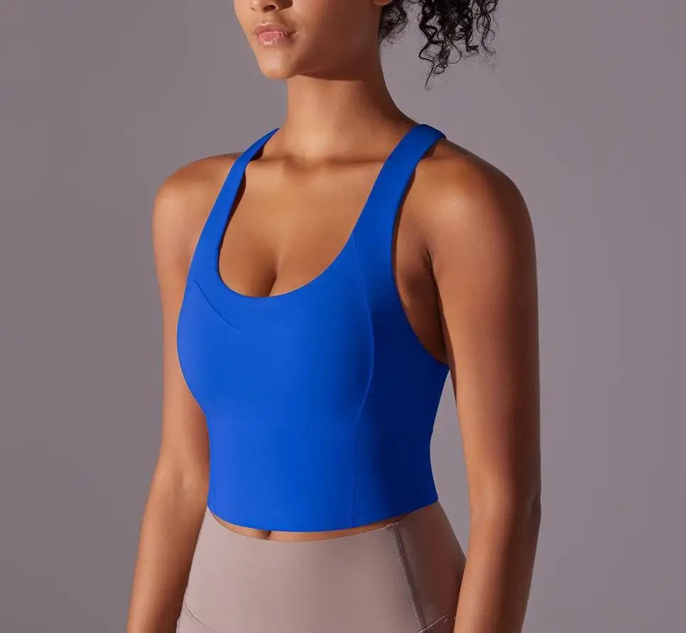 Blue seamless crossback sports bra for women by KiKis modeled with beige leggings