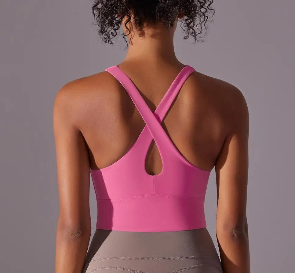 Pink seamless crossback sports bra for women shown from the back with crisscross straps