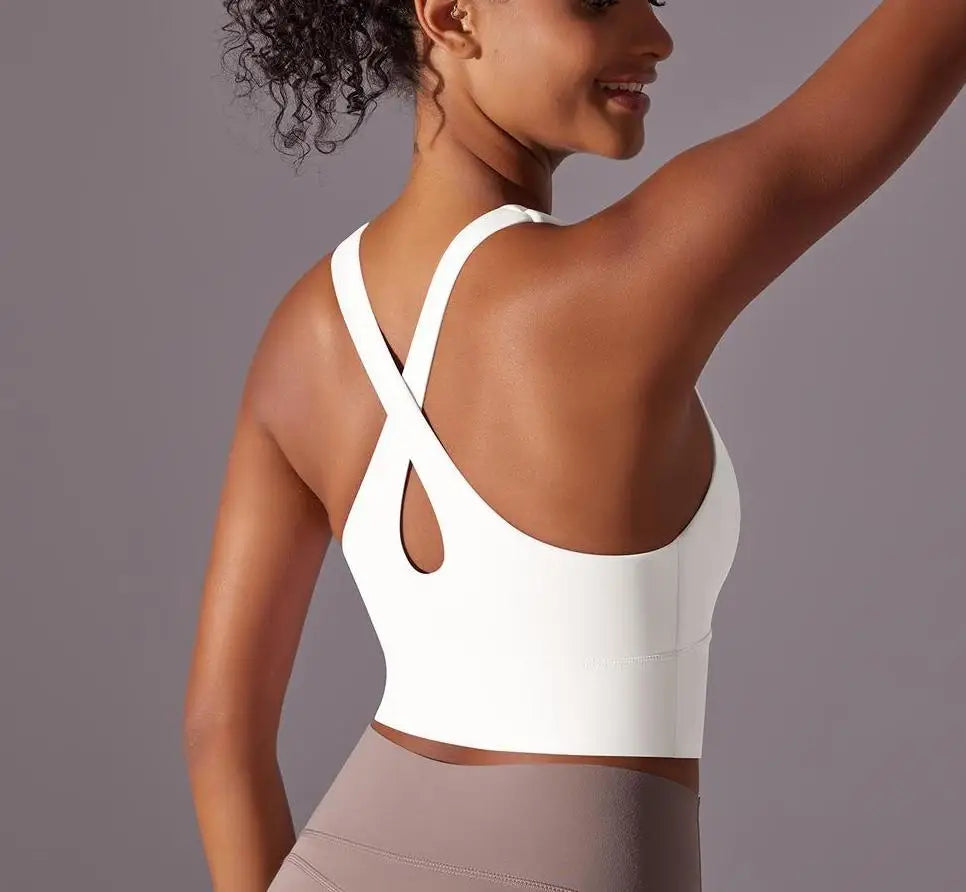 Woman wearing white seamless crossback sports bra for women showing back design and fit