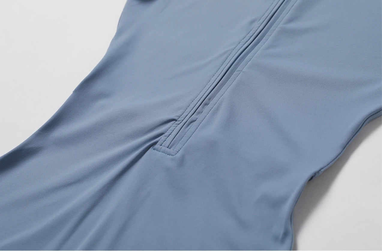 Close-up of blue fabric with zipper detail on the nude one-piece yoga jumpsuit by KiKis