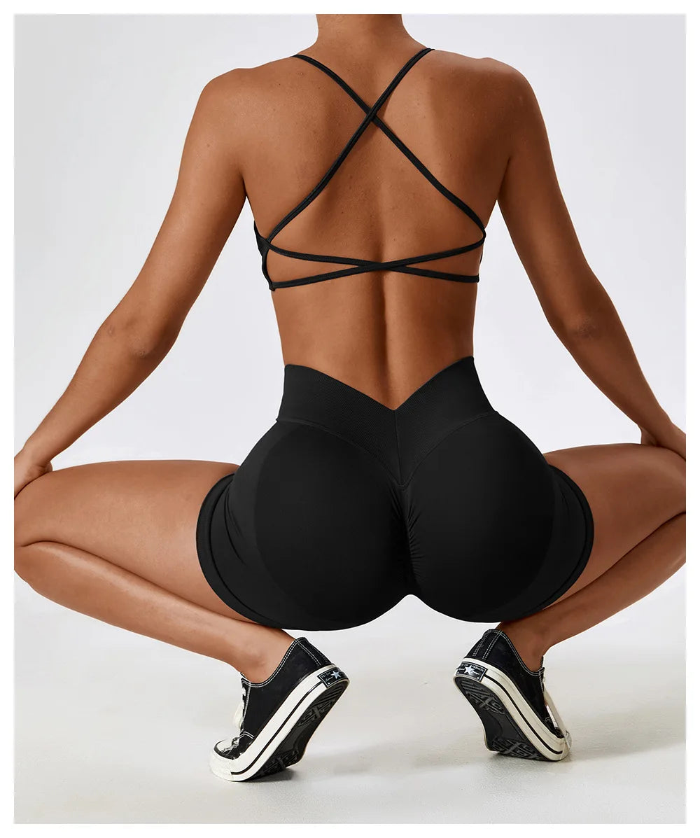 Woman wearing black seamless scrunch butt gym shorts in a squatting pose showing fit and design