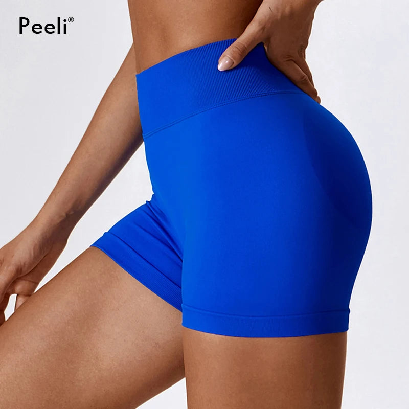 Blue seamless scrunch butt gym shorts by KiKis showing side view and high waist design