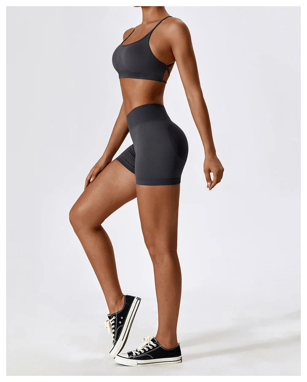 Woman wearing seamless scrunch butt gym shorts and matching sports bra in dark gray