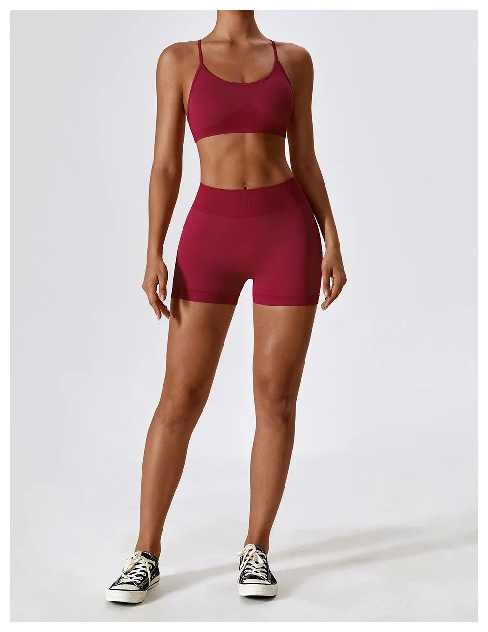 KiKis seamless scrunch butt gym shorts in burgundy worn by a fit woman with matching sports bra